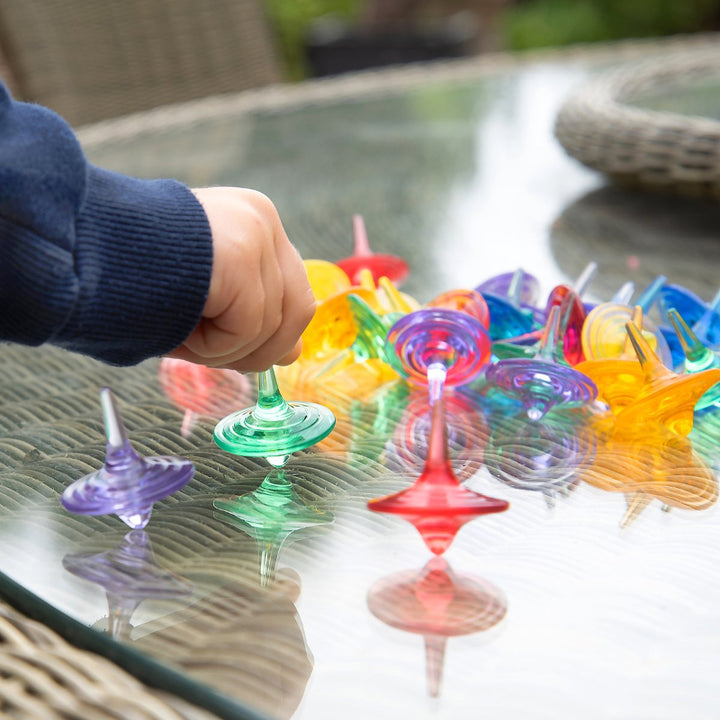 doorschijnde transparente tollen van ticket op tafel met glasplaat en kinderhands, fijne motoriek speelgoed