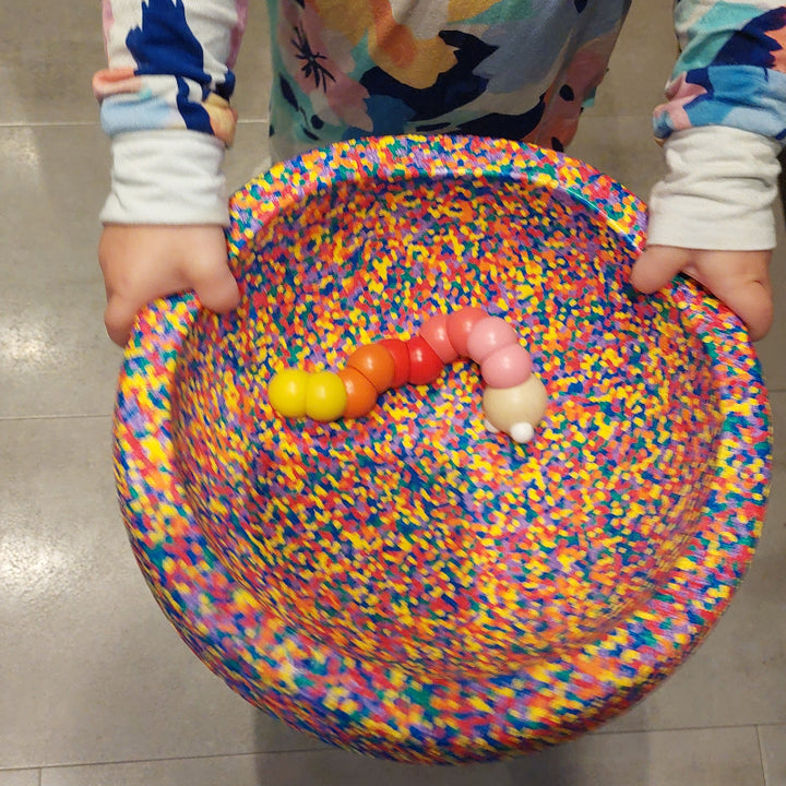 pocketpuzzel worm in confetti stapelstein met kinderhanden, twee handig spelen,  motoriekspeelgoed
