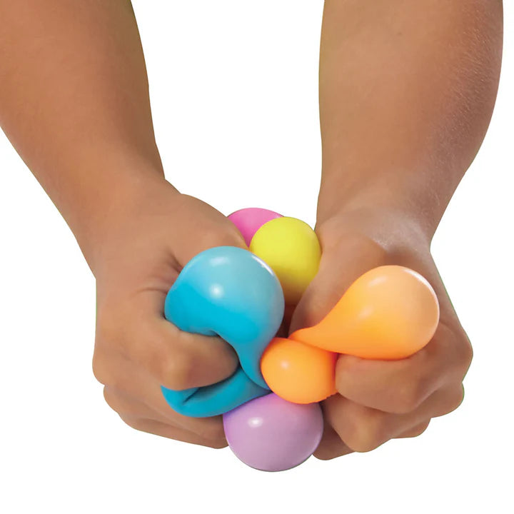 regenboog needoh in handen, kinderhanden drukken alle 6 teenie ballen 