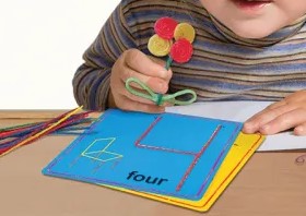 kind aan het spelen met wikki stix cijferkaarten