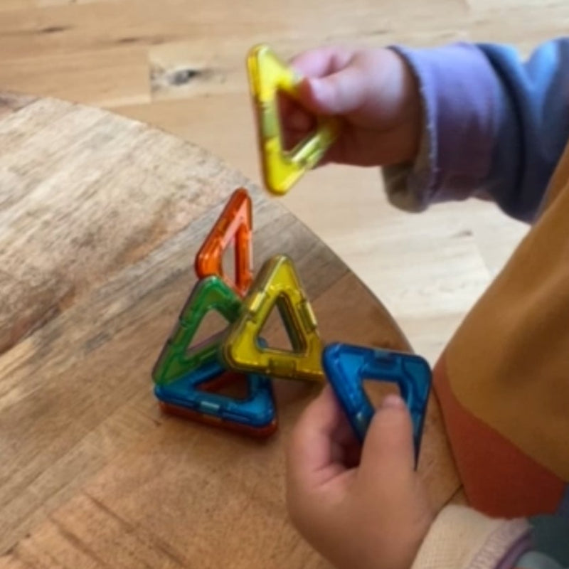 twee kinderhanden die met magformer magneten spelen, driehoek magformer
