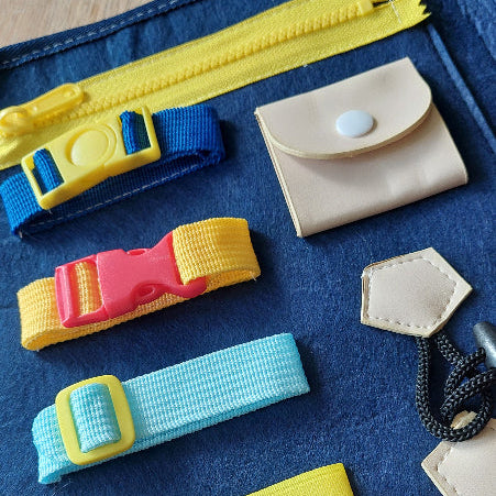 Toys42Hands Sluitingen tasje, details van een kant van het boekje met gesp,drukknop, rits , motoriekspeelgoed