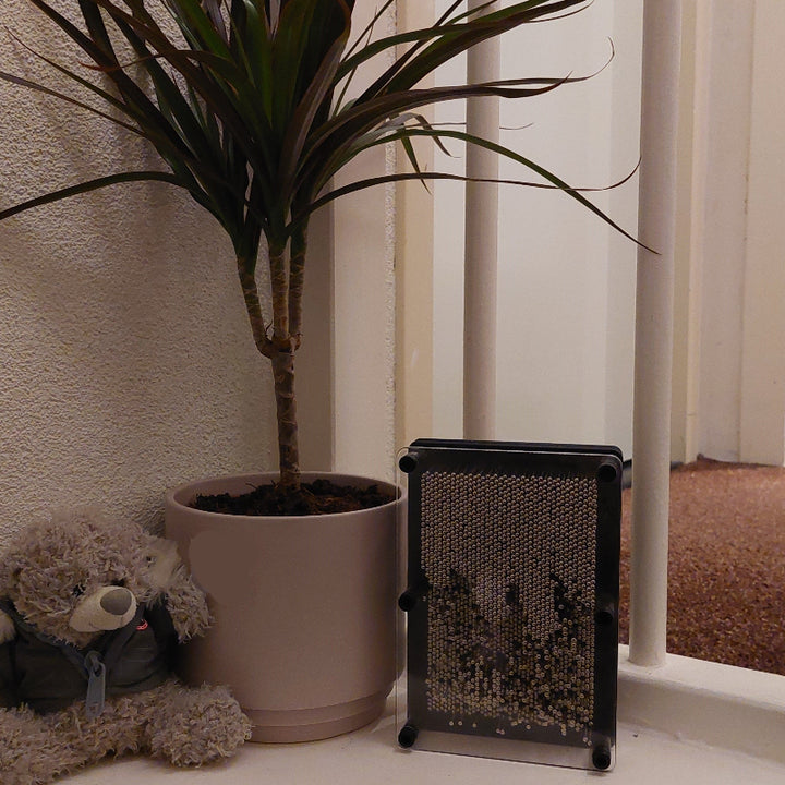 pin pression van metaal voor jong en oud, handafdruk naast teddybeer en plant, decoratie